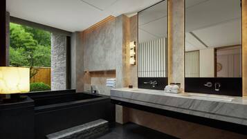 Un baño moderno con un espejo grande, lavamanos dobles y un banco incorporado.