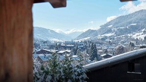 Un pueblo de montaña cubierto de nieve con edificios de madera tradicionales y una vista despejada del paisaje circundante.
