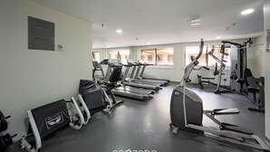 A gym with treadmills, weight machines, and a mirror wall. - Flat at Comfort Suites Brasilia Coa0314 (Brasília)