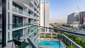 A modern hotel with a rooftop pool, glass railings, and a view of the cityscape. - Modern Studio at Paragon (Dubai)