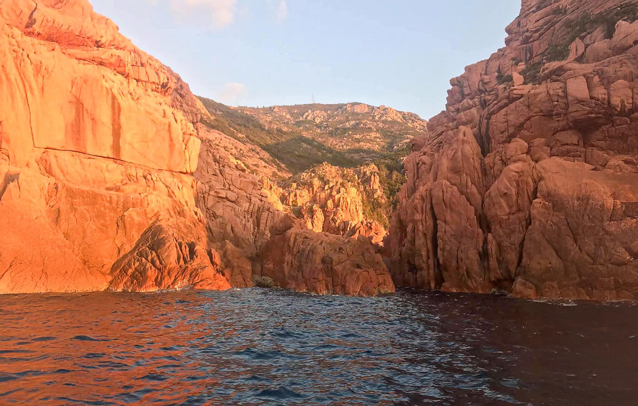 Un canyon aux parois rocheuses abruptes, avec une étendue d’eau au premier plan.