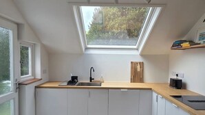 A compact kitchen with a skylight, a sink, and a countertop.