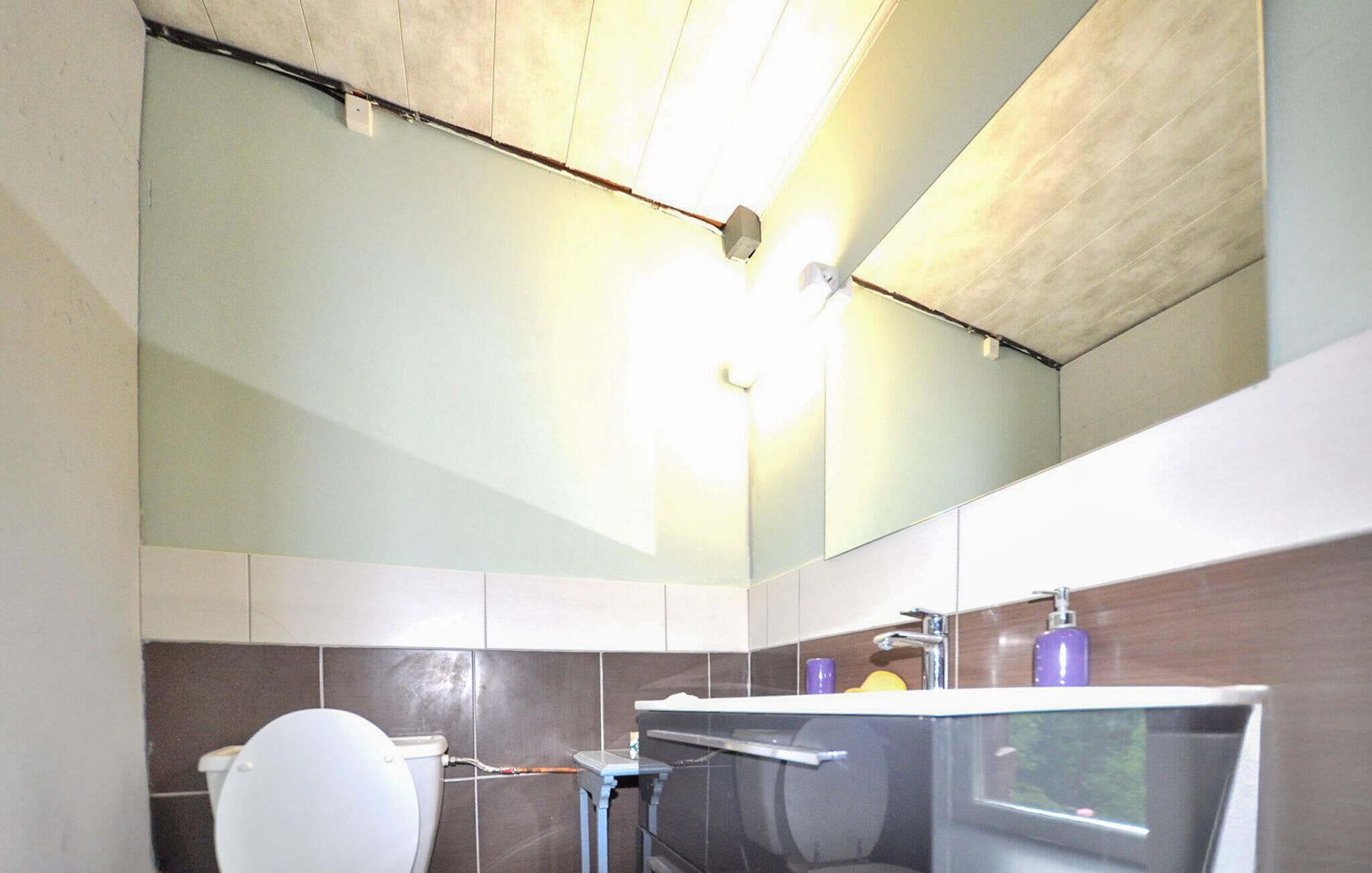 A modern bathroom with a toilet, sink, and shower.