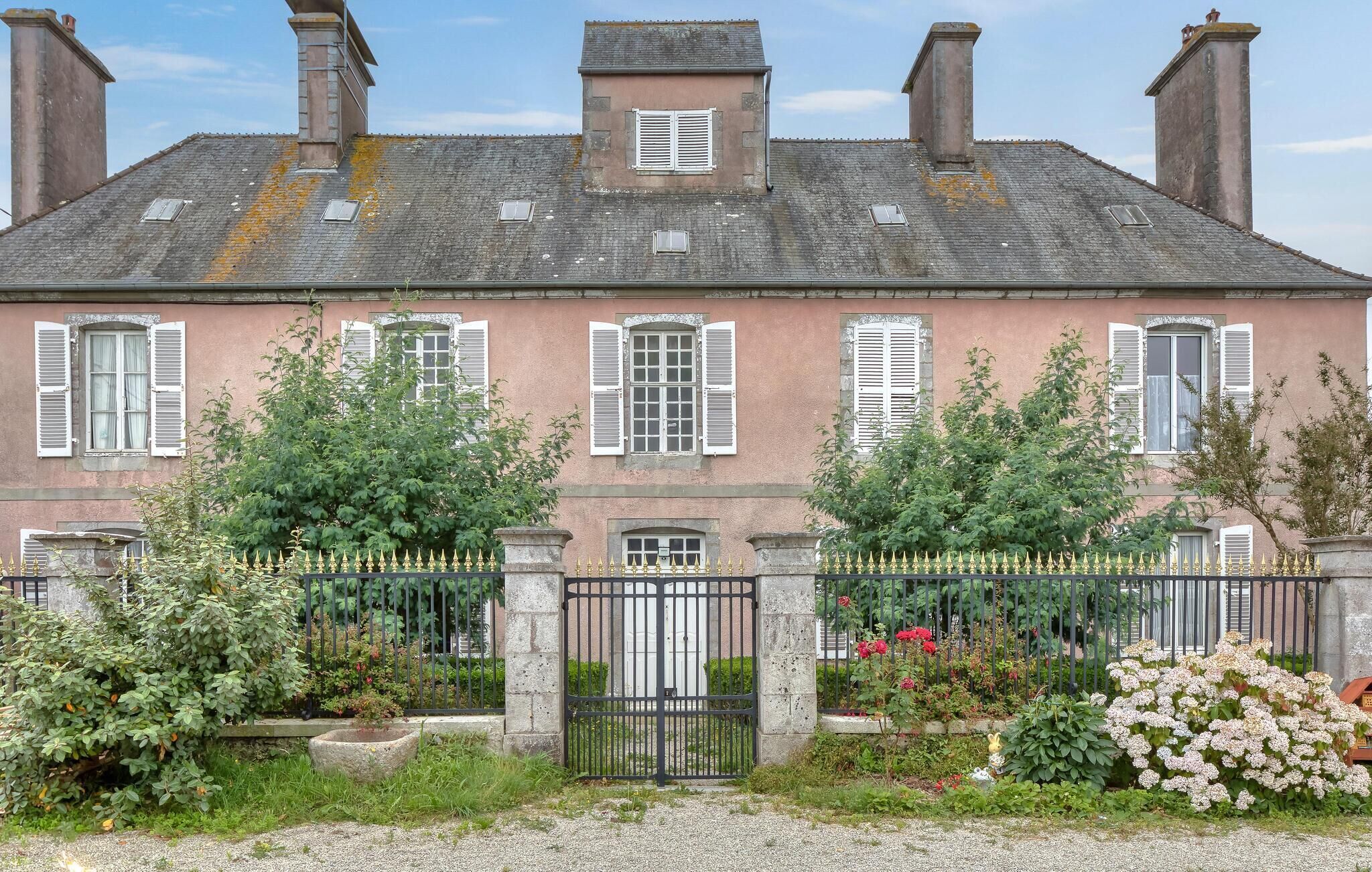 A large, historic building with multiple windows and a gated entrance.
