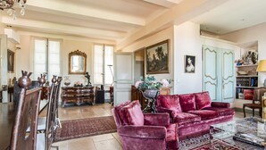 A spacious living room with a red velvet sofa, a wooden cabinet, and a large mirror. - Amazing home in Tourrettes with sauna (Tourrettes)