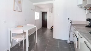 A modern kitchen with a dining area, a coffee machine, and a mop.