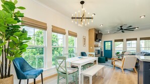 Una cocina moderna con comedor, ventanas amplias y ventilador de techo.