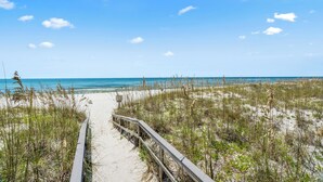 A sandy beach path with a wooden railing leading to the ocean. - Santa Rosa Dunes 912 | Olympic Size Pool & More | My Beach Getaways (Pensacola Beach)