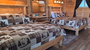A cabin with two wooden beds, a small table, and a window with curtains.