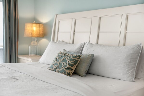 A neatly made bed with a white headboard, two pillows, and a bedside lamp. - Direct Oceanfront Indialantic Getaway – Balcony, Patio & BBQ Grill! (Indialantic)