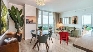 Un salon moderne avec un coin repas, de grandes fenêtres et une vue sur la ville.