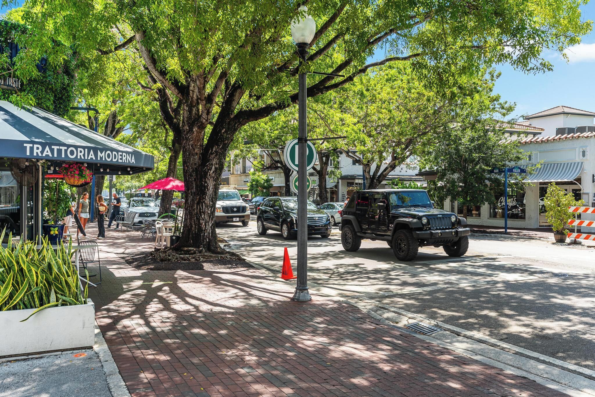 A street scene with a restaurant named 'Trattoria Moderna' and a parked SUV.