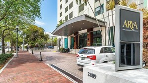 A hotel entrance with a modern design, a white car parked in front, and a sign indicating the hotel's name. - Stylish Studio at Hotel Arya | King Bed, Full Kitchen + City View Balcony (Miami)