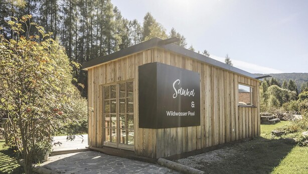 A wooden cabin with a sign reading "Saund Wildwasser Pool". - AlpiNest Obertauern Chalet 1 XL (Mariapfarr)