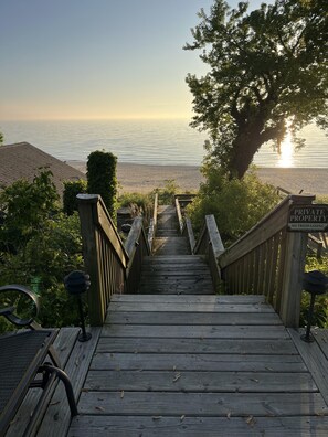 A wooden staircase leading to a beach with a 'Private Property No Trespassing' sign. - Endless Sunsets Cabin 1 (South Haven)
