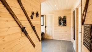 Un pasillo de madera con un esquirol, un cuadro y un letrero en la pared.