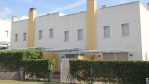 Un edificio moderno con techo plano, varias chimeneas y un área exterior cubierta.