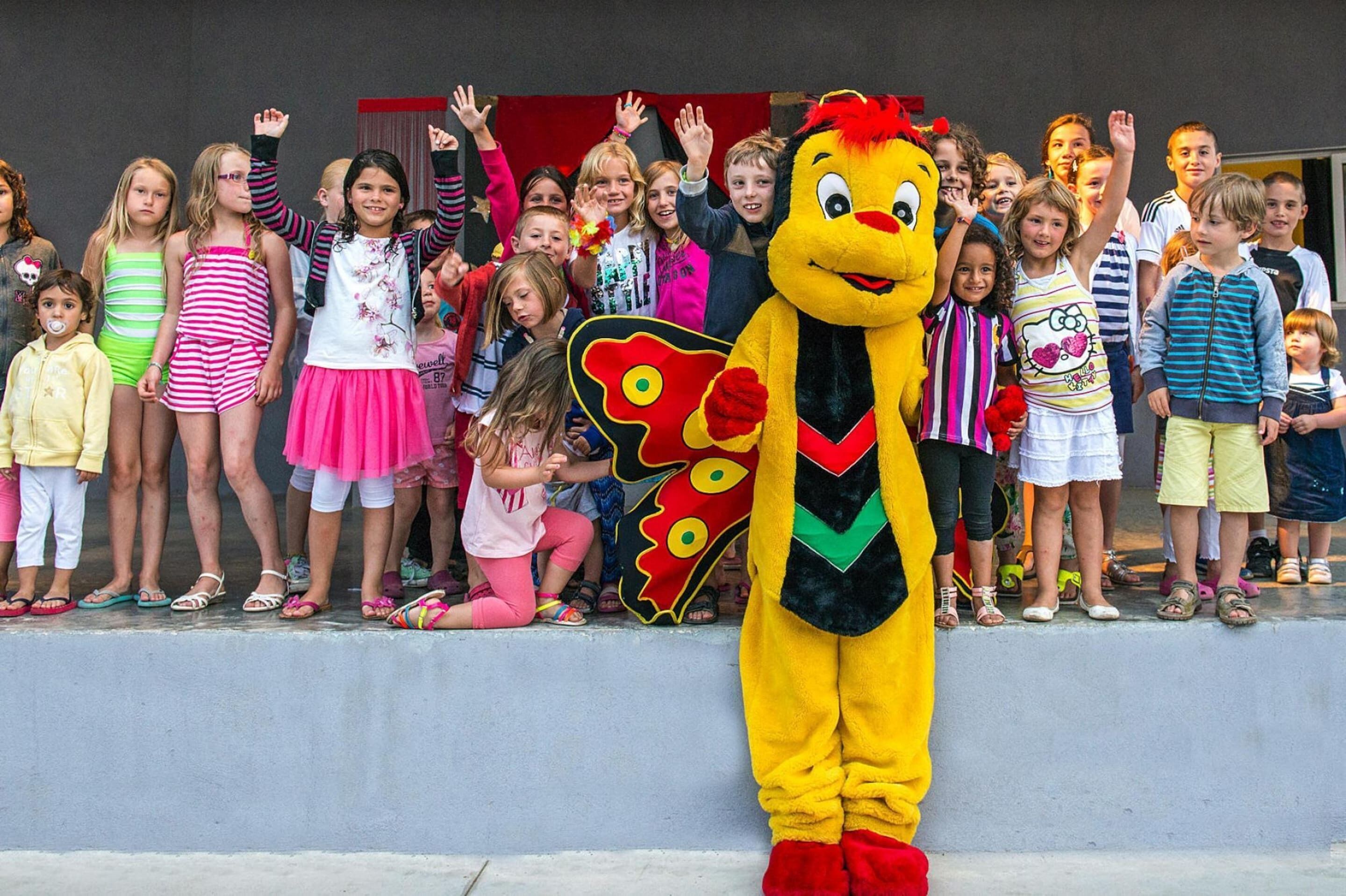 A mascot standing in front of a group of children.
