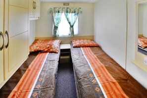 A room with two single beds, a window with curtains, a wardrobe, and a mirror. - Mobile Home by the Lake Beach (Malechowo)