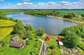 A rural landscape with a river, green fields, and several houses with red roofs. - Mobile Home by the Lake Beach (Malechowo)
