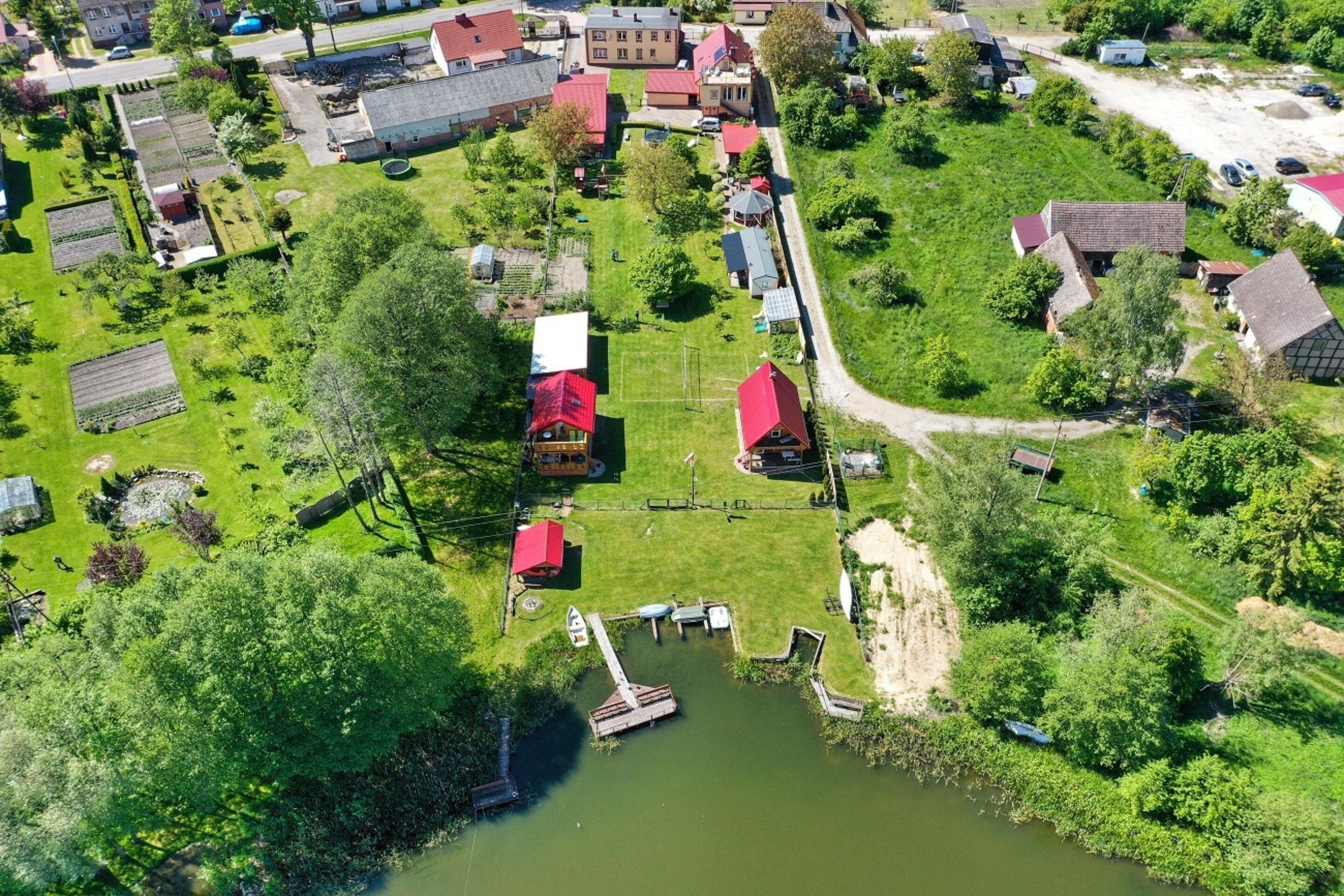 An aerial view of a residential area with houses, a dock, and a small body of water.