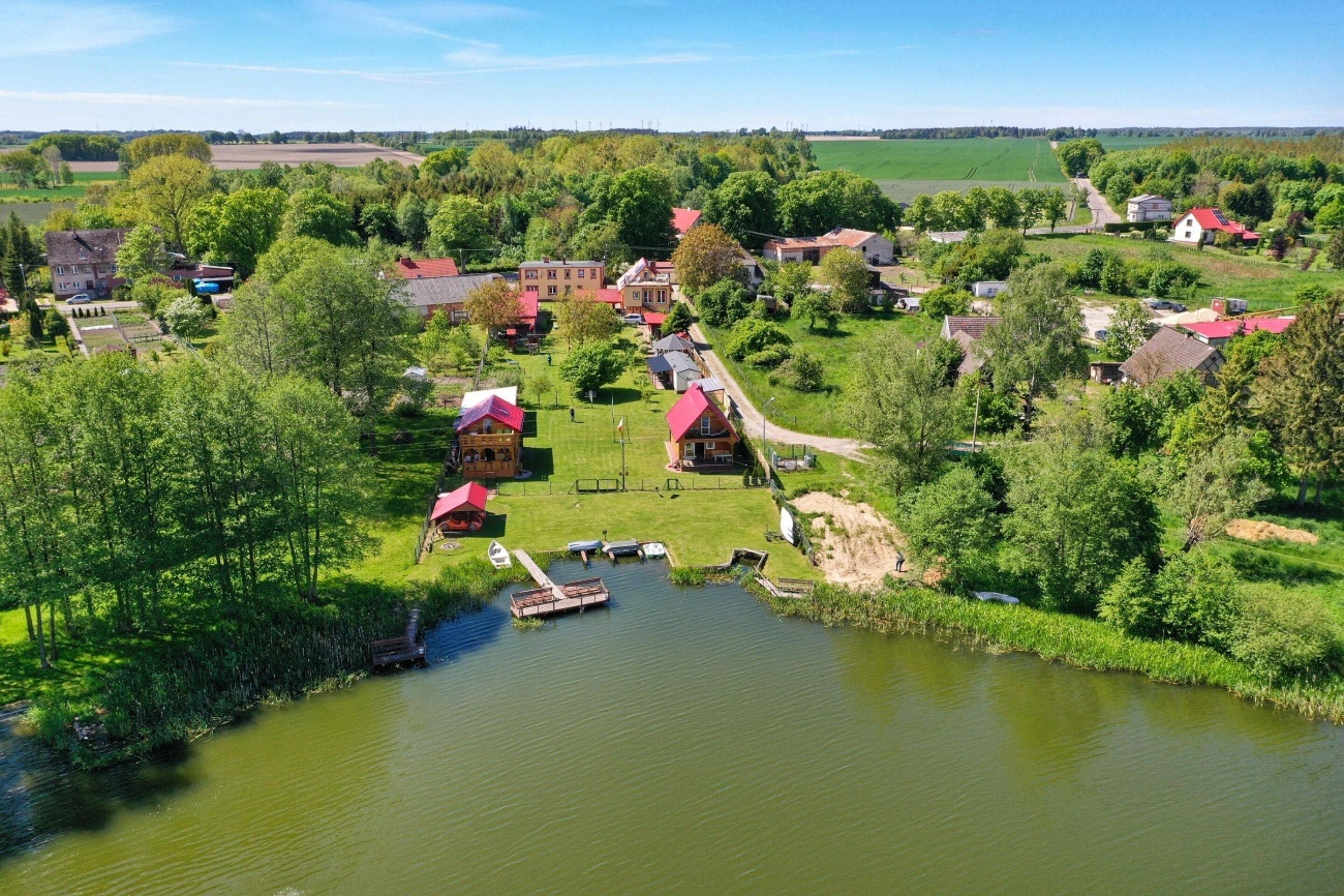 Een dorp aan de rivier met huizen, een steiger en boten.