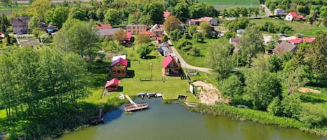 A riverside village with houses, a dock, and boats.
