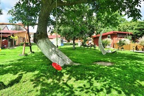 A well-maintained grassy yard with a swing set and a red disc. - Mobile Home by the Lake Beach (Malechowo)