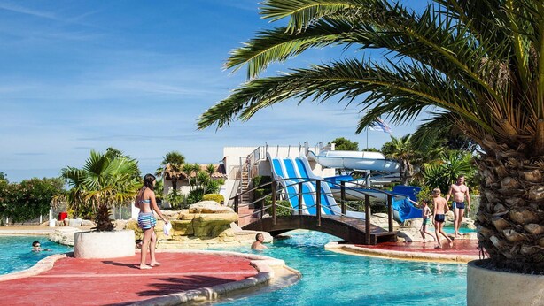 A swimming pool with a water slide and palm trees. - VIP Mobile Home With Terrace (Vendres)