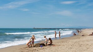 A beach with people engaging in various activities such as walking, sitting, and playing in the sand. - VIP Mobile Home With Terrace (Vendres)