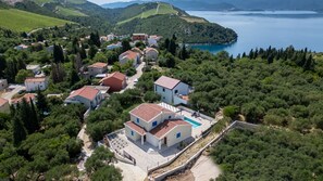 A coastal village with houses, a swimming pool, and a view of the sea. - Villa Olea by Villas Guide (Blace)