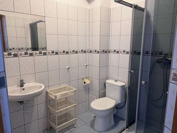 A bathroom with a sink, toilet, and shower. - Pokoje Alina (Grzybowo)