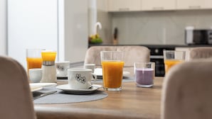 A breakfast setting with a table set for two, including a glass of orange juice, a white mug with a floral design, and a purple candle. - Villa Stjepan Zep (Kvarner - Županje) (Županje)