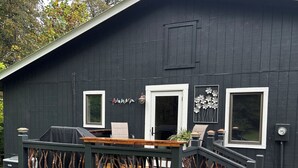 Un edificio negro con una terraza, una parrilla y una ventana.