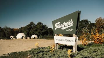 A sign for 'Ferncrest Acadia Campground & Commons' with a clear view of the surrounding landscape.