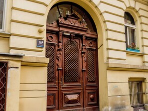 A large, ornate wooden door with intricate carvings and a number plate indicating the address. - Łąkowa Charming Studio (Poznań)