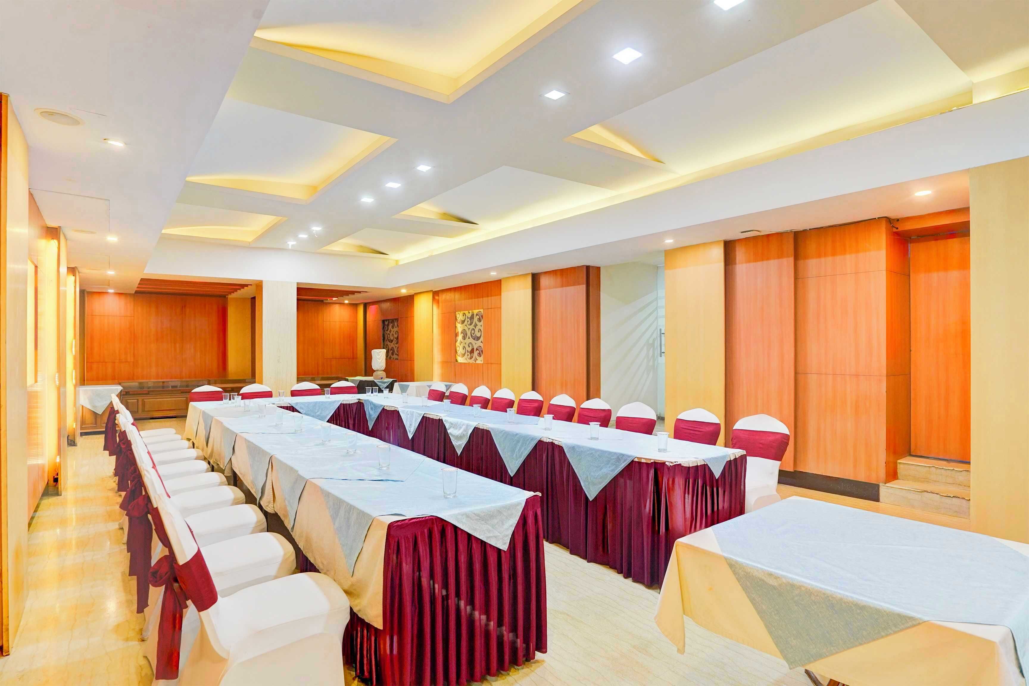 A conference room with long tables, red and white chairs, and a modern ceiling design.