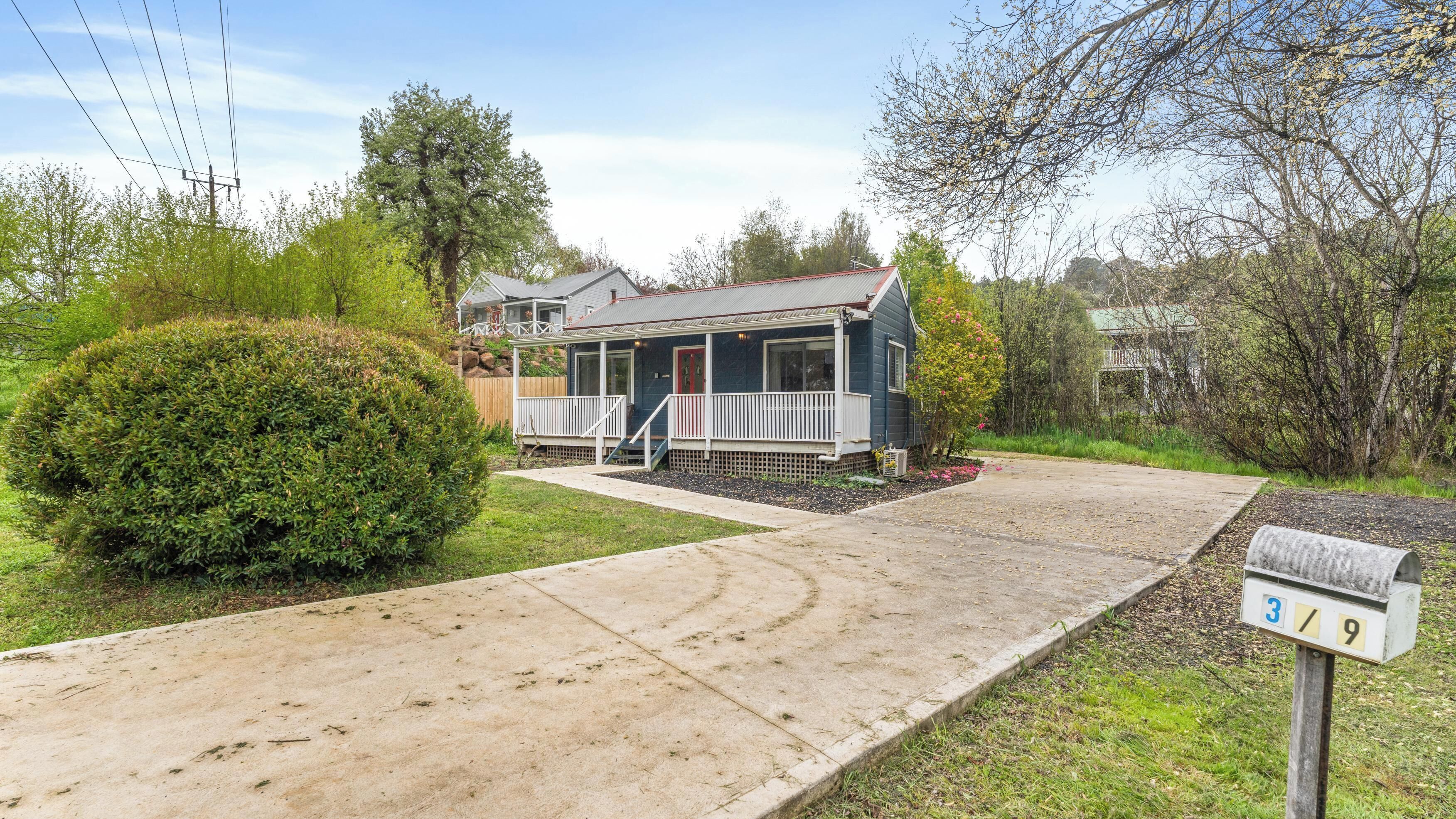 A single-story house with a front porch, a mailbox, and a well-maintained lawn.