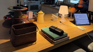 A kitchen with a wooden countertop, a laptop, a coffee maker, and various kitchen appliances.