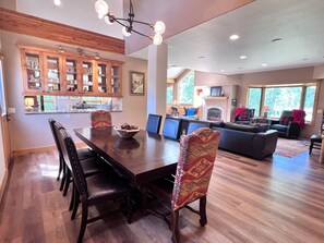 A dining area with a wooden table, chairs, and a bowl of pinecones.