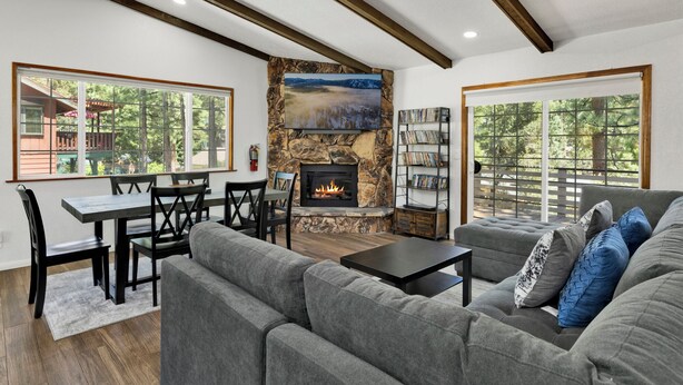 A living room with a stone fireplace, a sofa, a coffee table, and a bookshelf.
