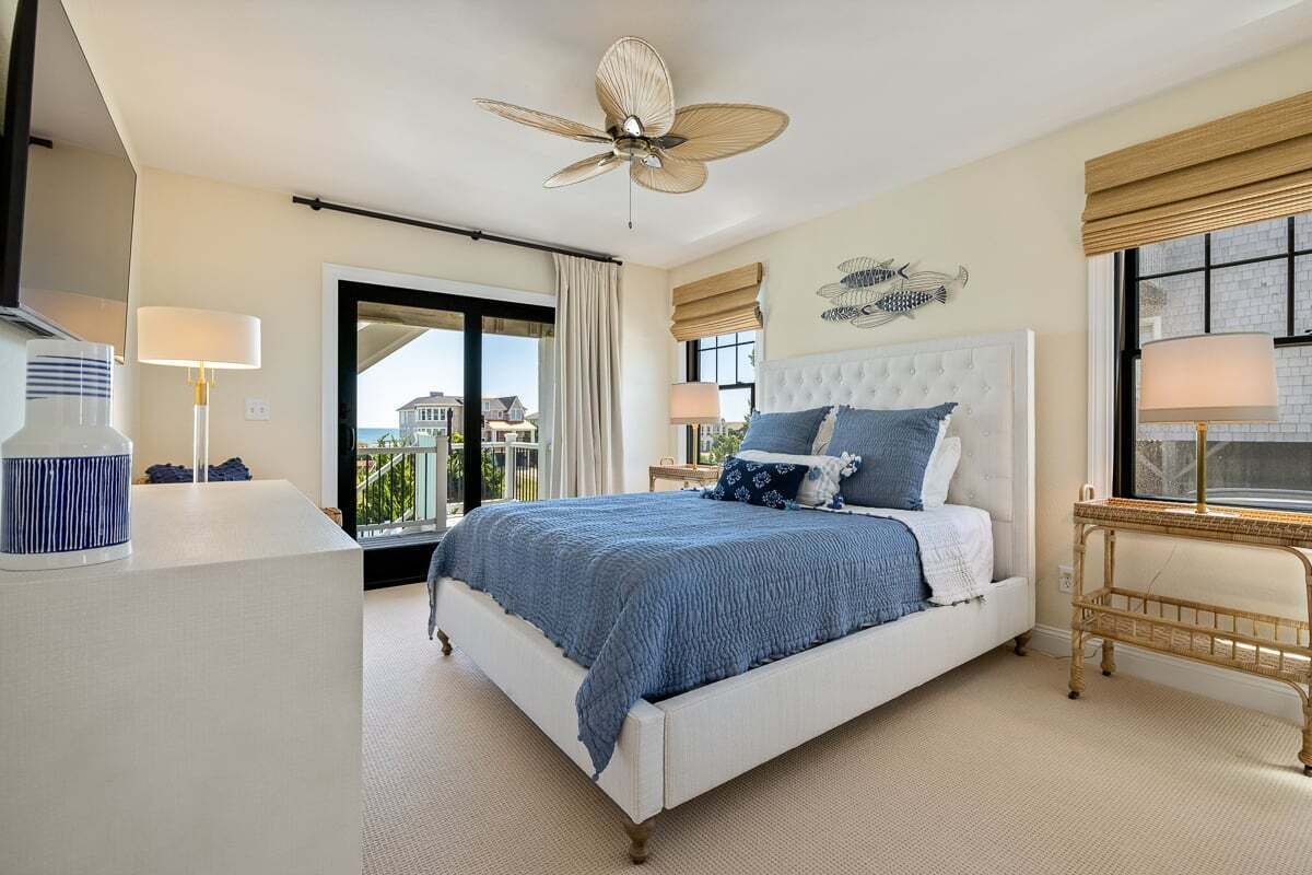 Camera da letto con un letto grande, una ventola a soffitto e vista sugli edifici.