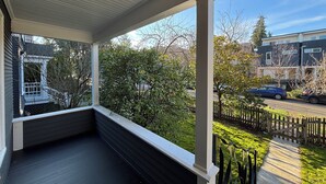 Un portico coperto con vista su una strada residenziale e un recinto.