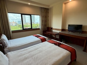 A hotel room with two beds, a desk, a television, and a window with a city view. - Sunday Grand Jomtien Pattaya (Pattaya)