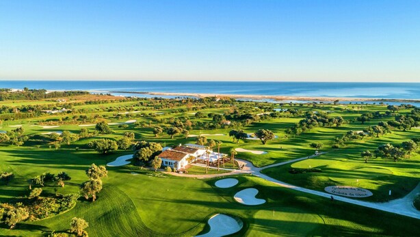 Un parcours de golf doté d’un club-house et offrant une vue sur l’océan.