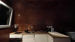 Eine kleine Küche mit Holzwänden, einer eingebauten Spüle und einer Arbeitsplatte.