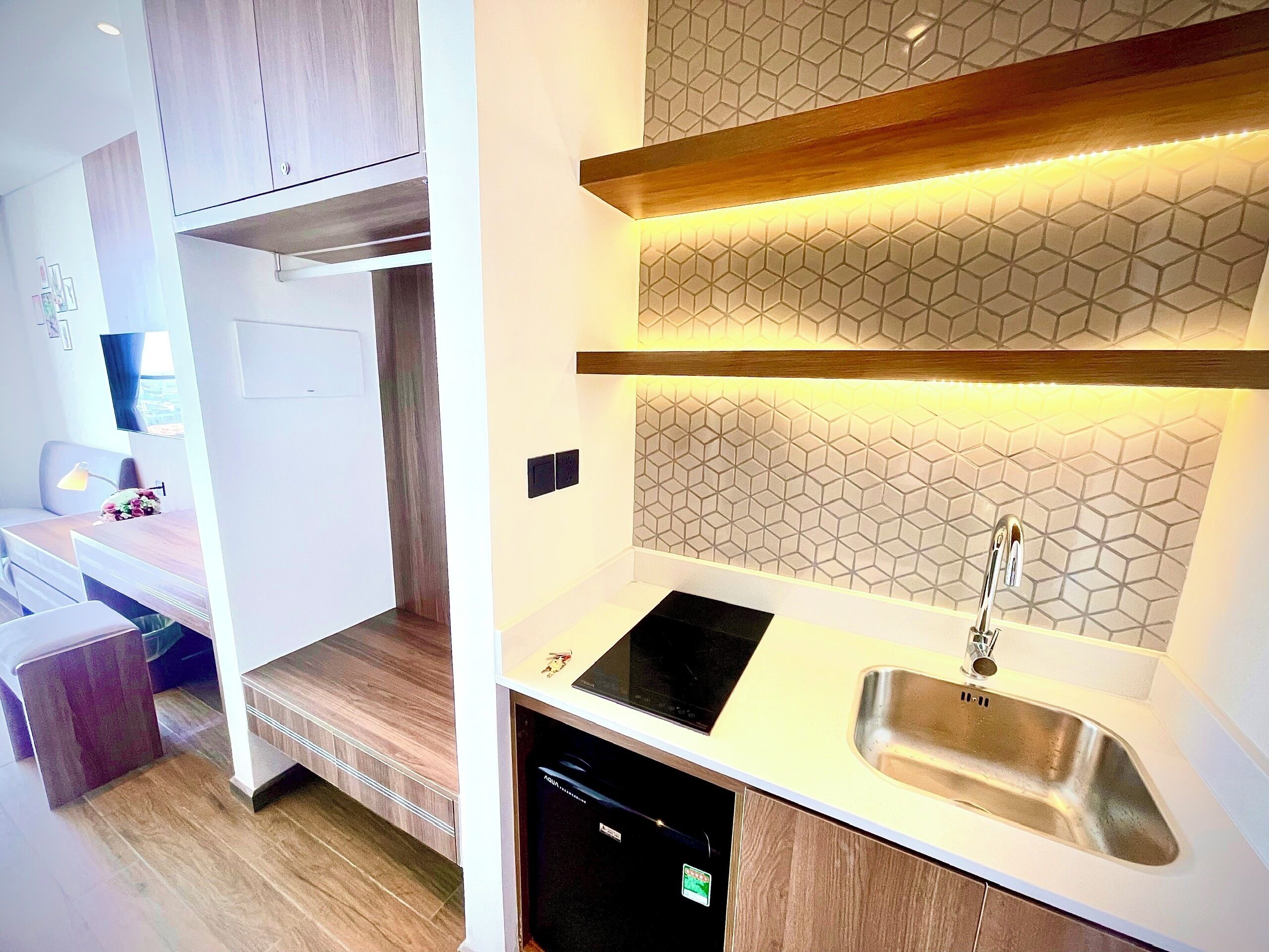 A modern kitchen with a built-in dishwasher, a sink, and a countertop with a hexagonal tile backsplash.
