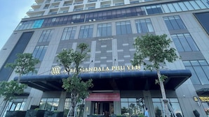 Un grand bâtiment moderne, sur lequel on peut voir une enseigne bien visible indiquant « APEC Mandala Phu Yen ».