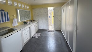 A compact kitchen with a built-in dishwasher, a sink, and a mirror above it.