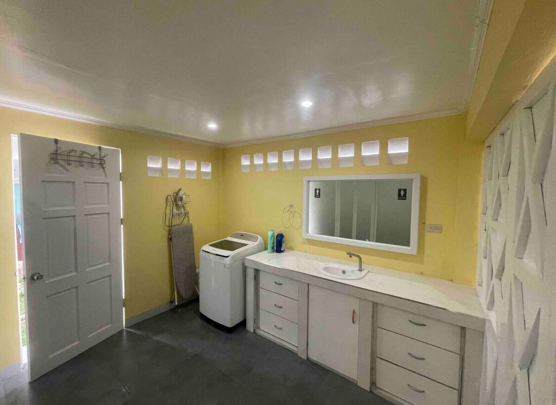 A bathroom with a white sink, a mirror, and a towel rack.